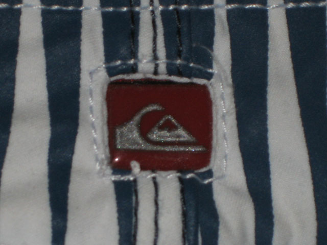 Genuine shorts features rubber clear square with silver logo.