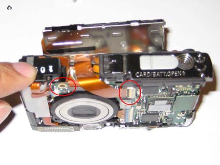 The screw holding the tripod mount at the front and the main ribbon cable connector